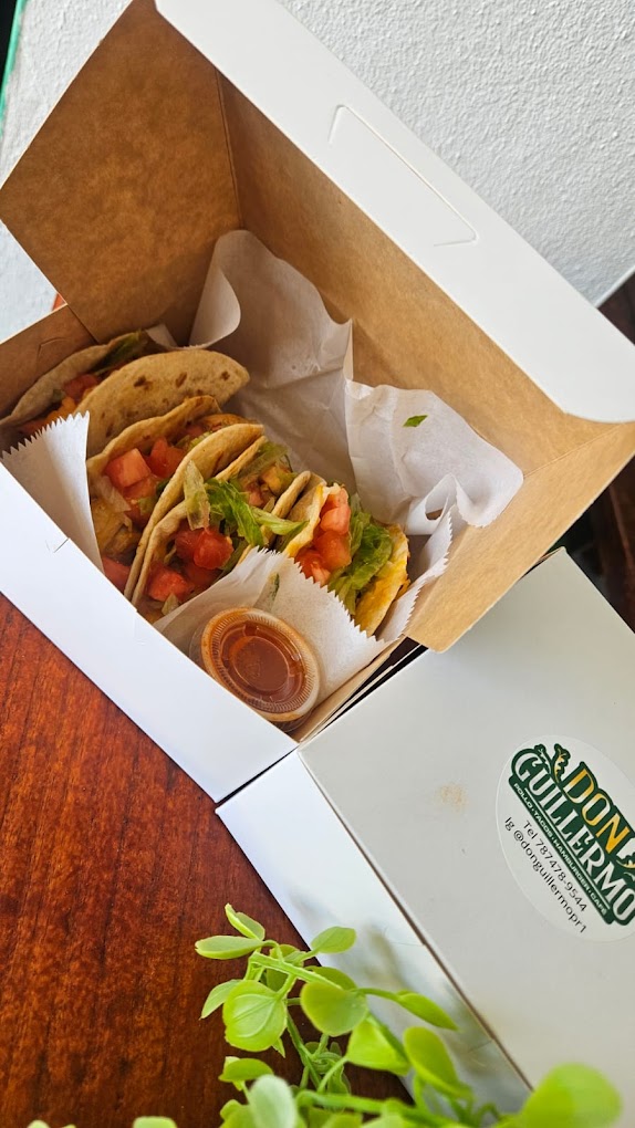 Tacos with lettuce, tomato, and cheese served in a box
